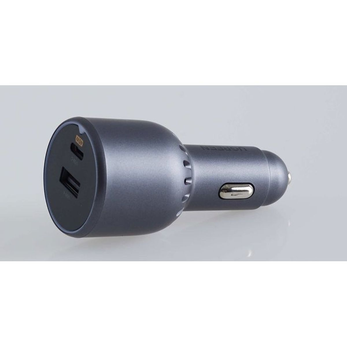 Szary adapter ładowarki samochodowej z dwoma portami USB i srebrnym przyciskiem.