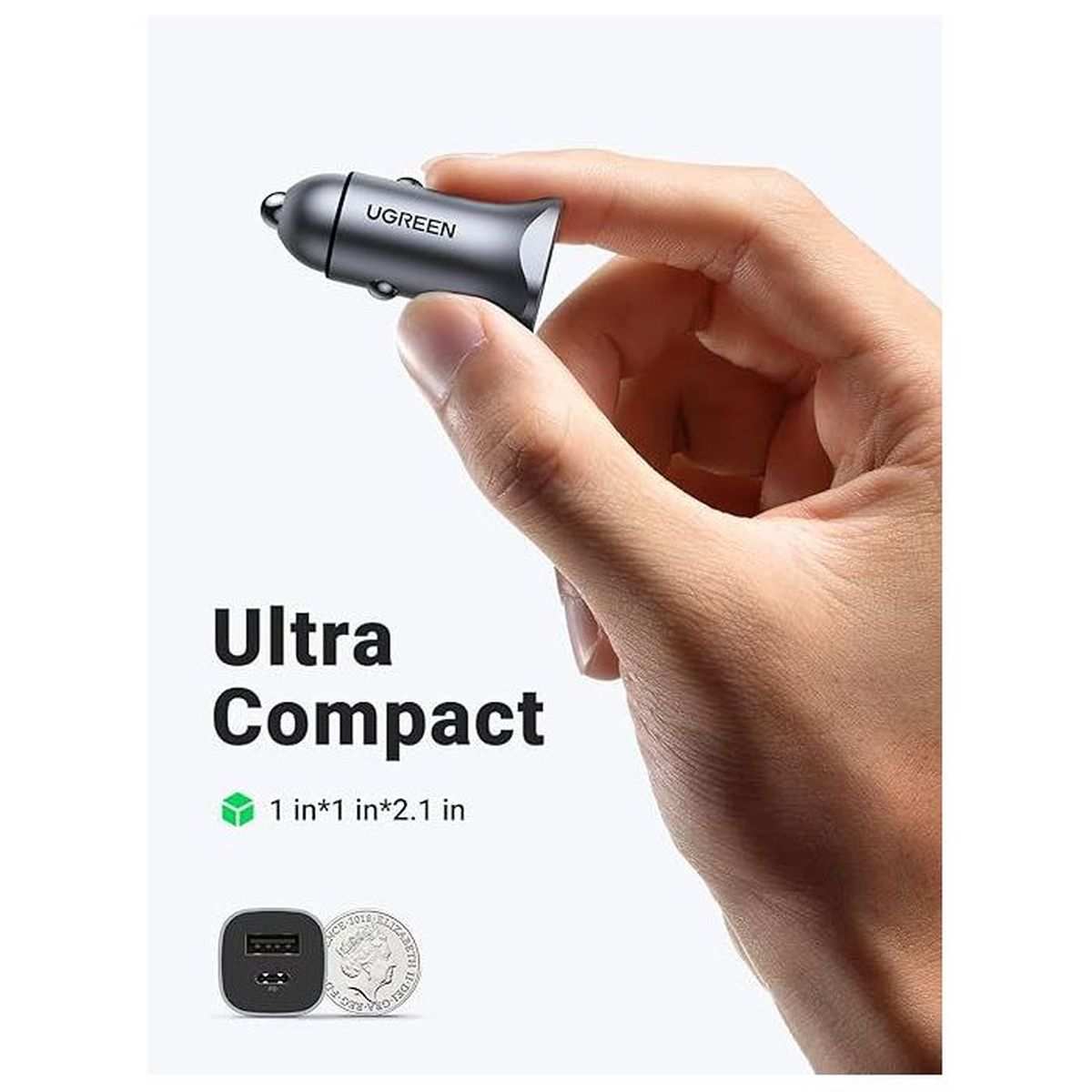 Szary adapter samochodowej ładowarki USB w dłoni obok monety.