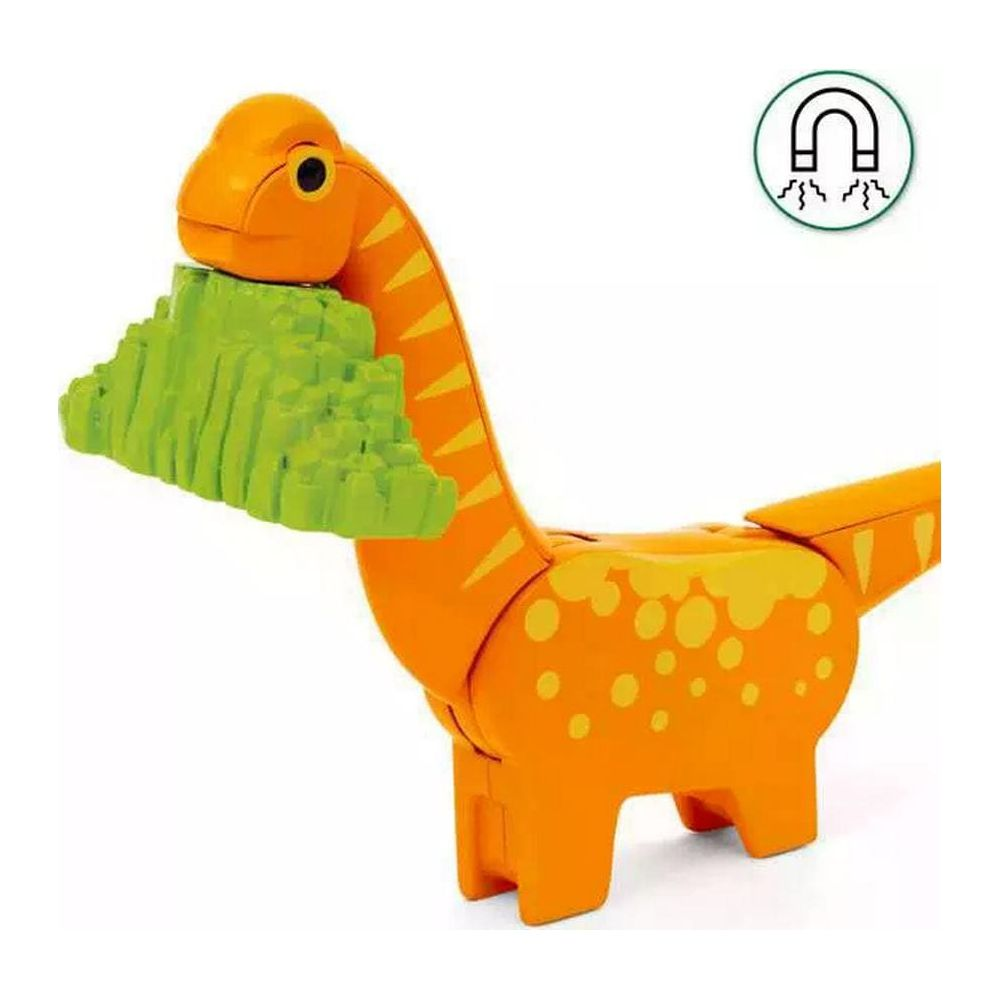 Pomarańczowy dinozaur-zabawka z zieloną skałą w pysku. Symbol magnesu w górze.
