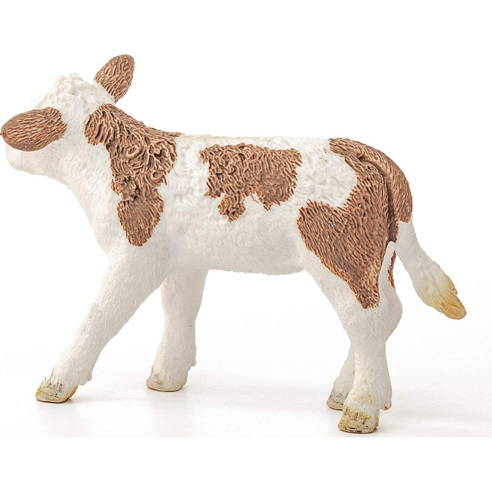 Białe cielę z brązowymi łatami stoi na białym tle.