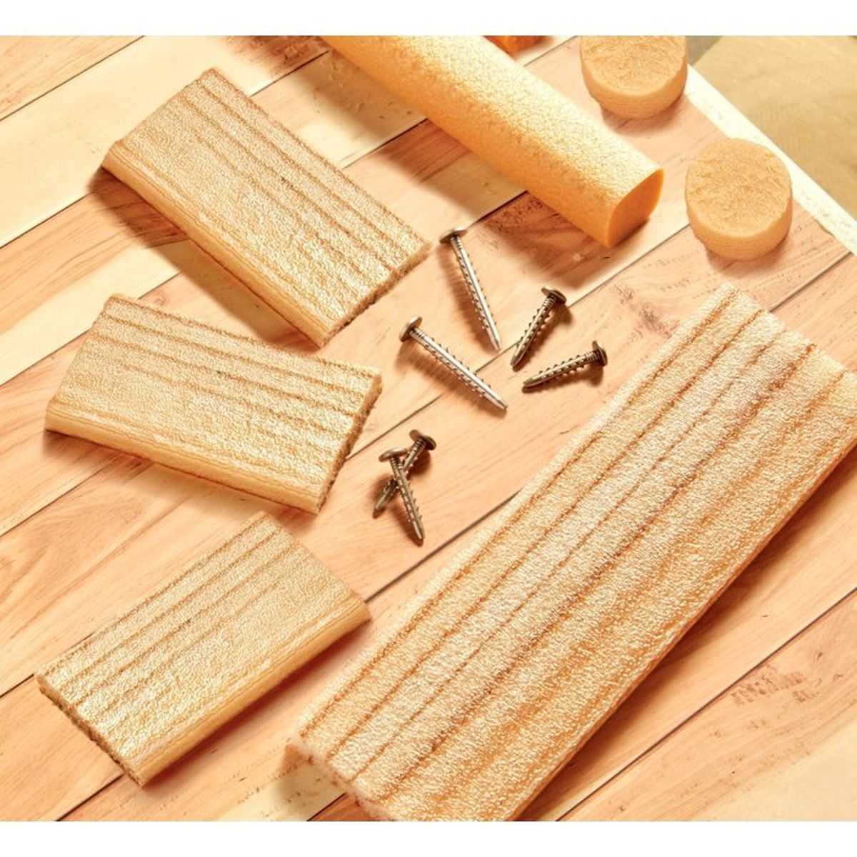 Holzdielen, Schrauben und oranger Schaumstoffrolle auf Holz.