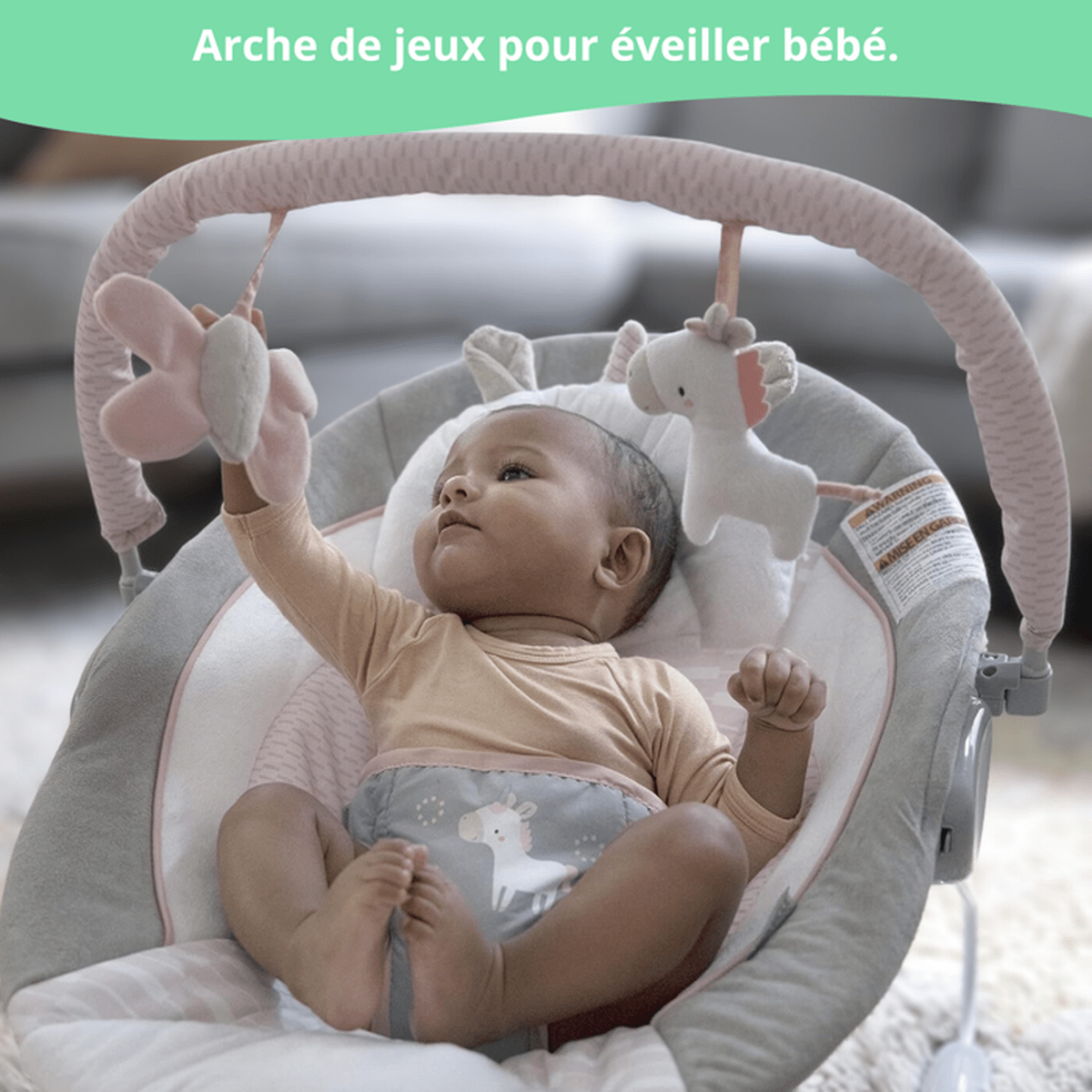 Baby in einem Spielbogen-Schaukelstuhl mit Spielzeug; Nahaufnahme.