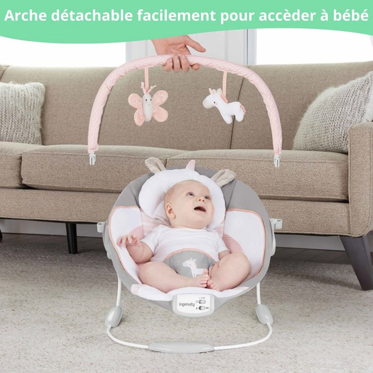 Baby in Schaukelstuhl mit Spielzeugbogen und Schmetterlings- und Einhornanhängern.