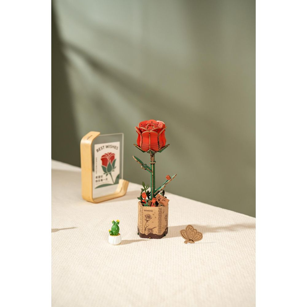 Drewniany model róży w doniczce z kartką.