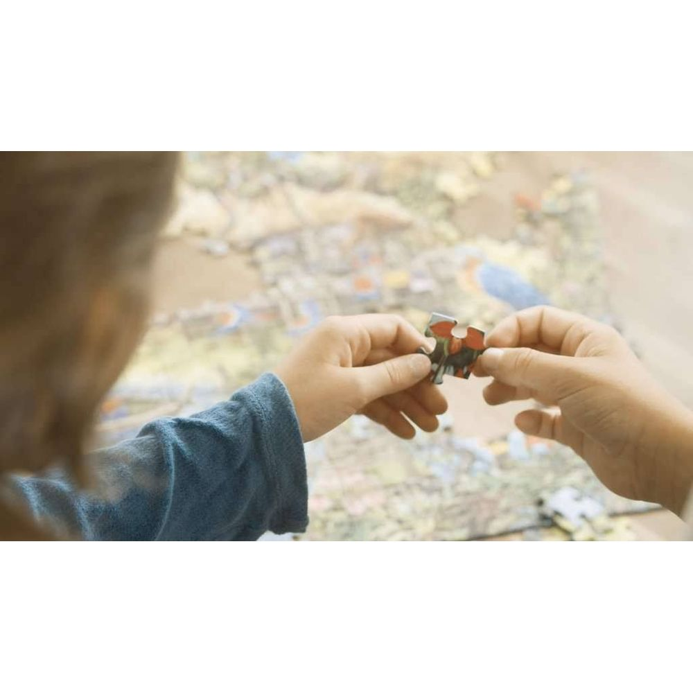 Ręce trzymają element układanki nad niedokończoną układanką.