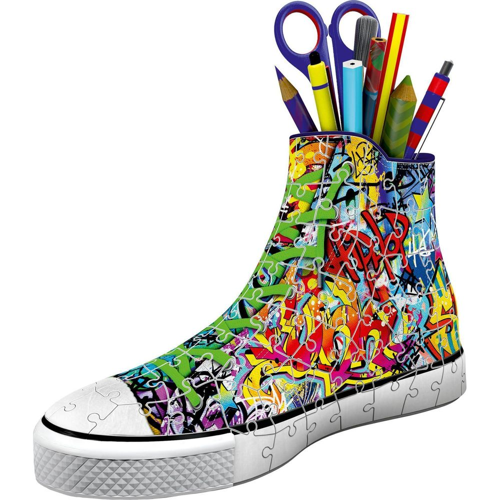 Une basket colorée en pièces de puzzle, contenant stylos et ciseaux.