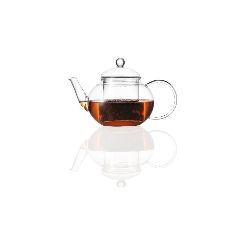 Eine Teekanne aus Glas mit Tee und einem Griff, die auf einer spiegelnden Oberfläche steht.