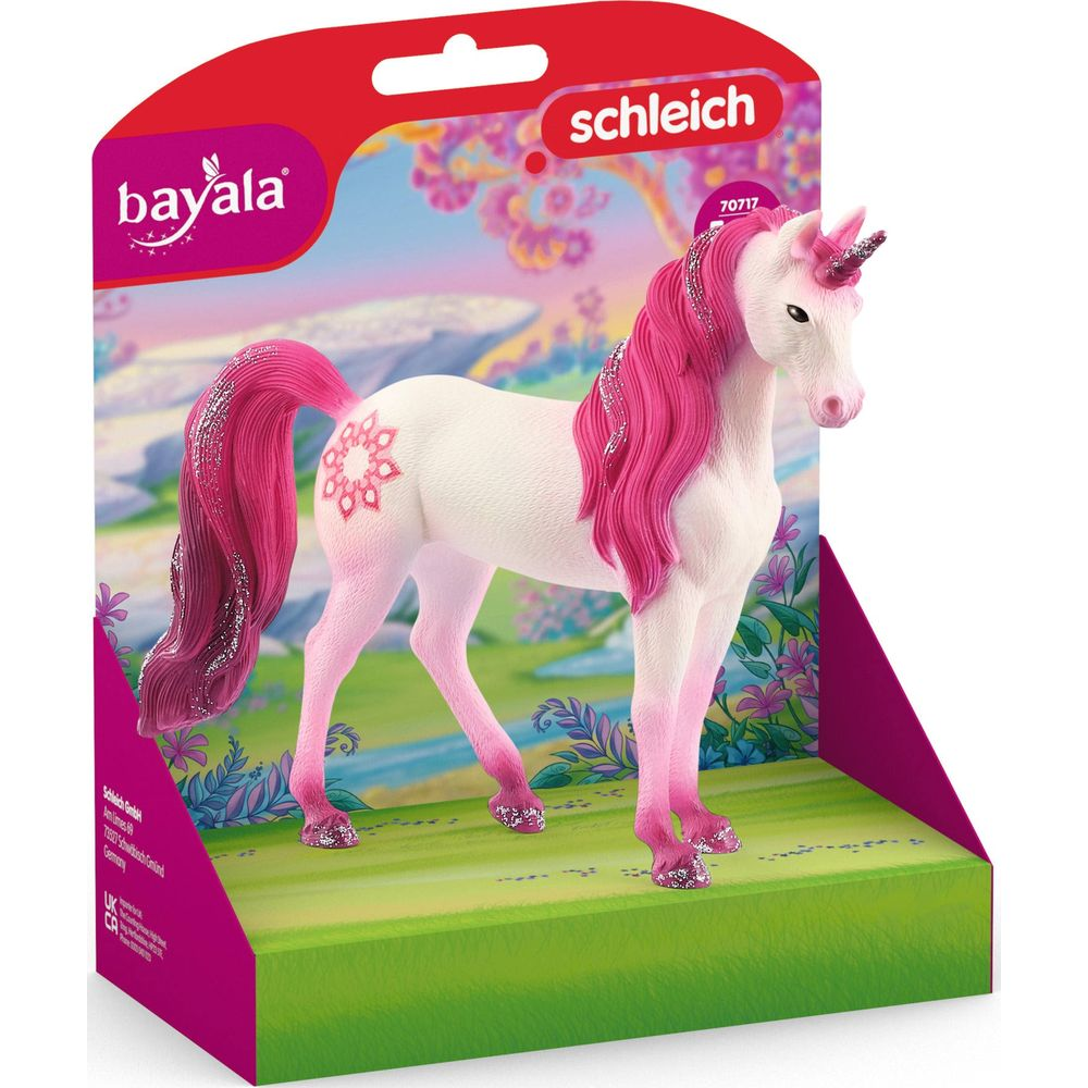 Biały jednorożec z różową grzywą i brokatem stoi na zielonej łące.