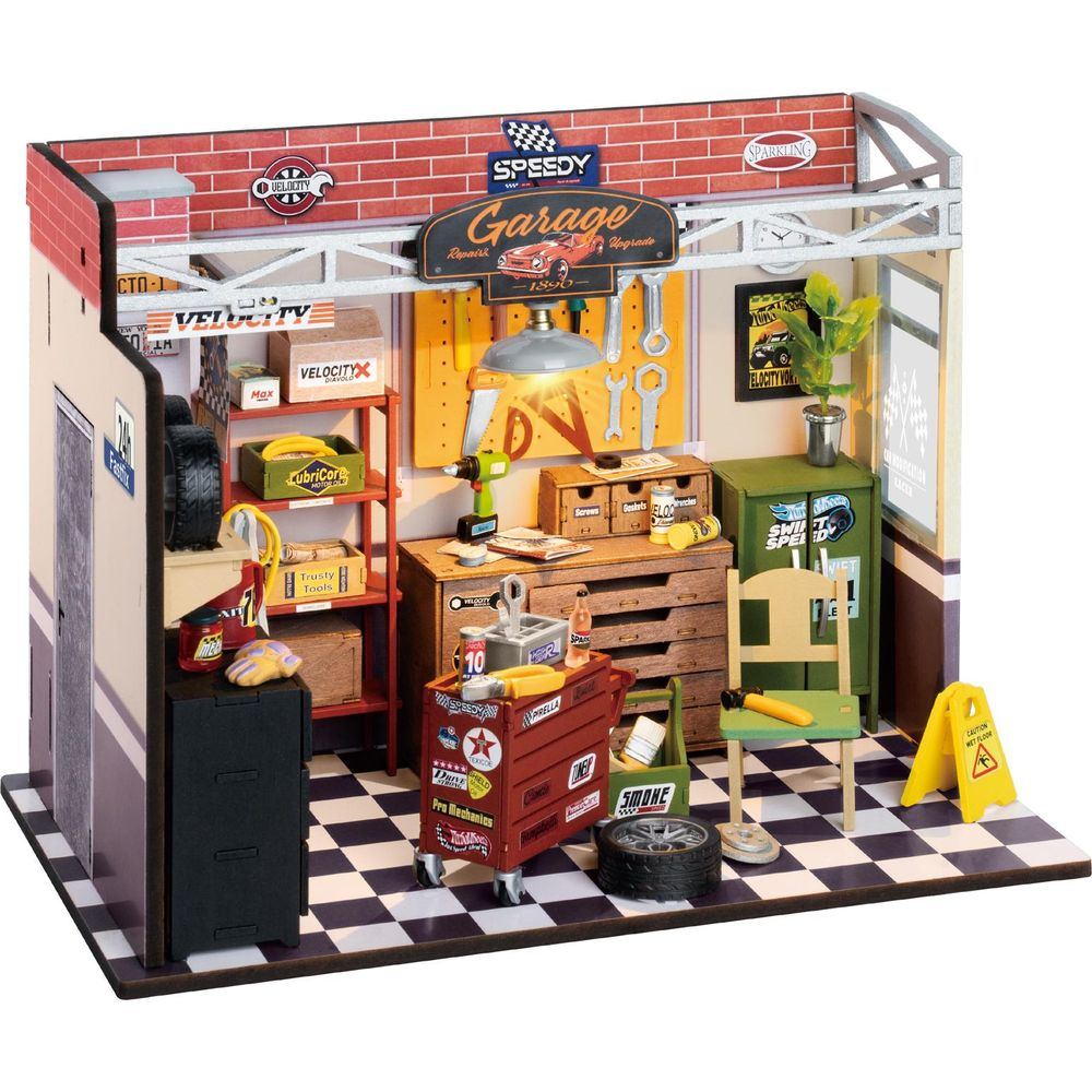 Eine Miniatur-Garage mit Werkzeugen, Reifen und einem Werkzeugwagen auf kariertem Boden.