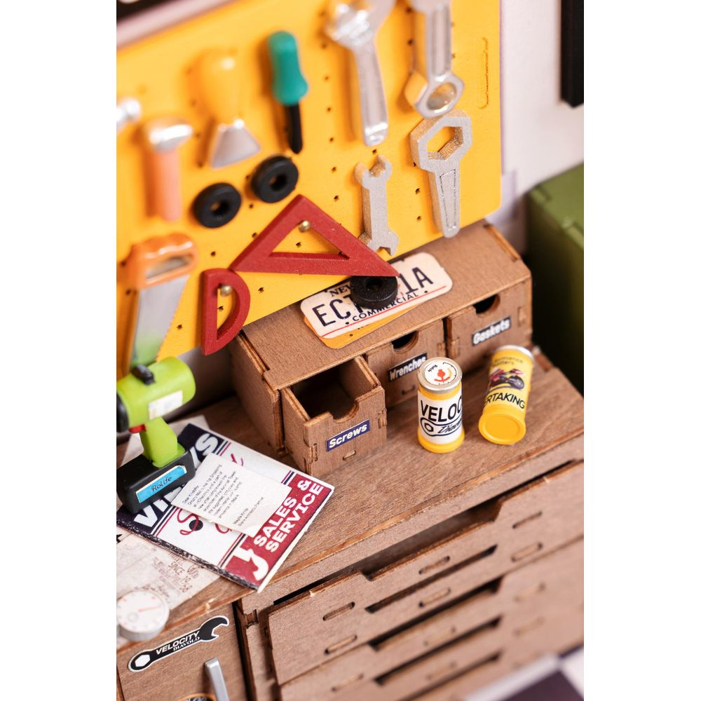 Miniatur-Werkstatt mit Werkzeugen, Schubladen und Dosen. Gelbe Werkzeugwand.