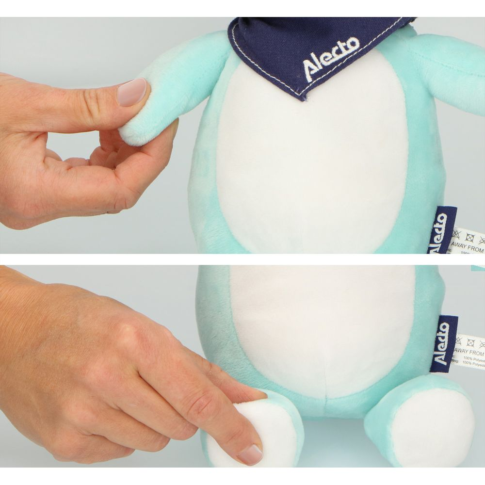 Een hand houdt de arm vast van een turkoois pluche speelgoed met bandana.
