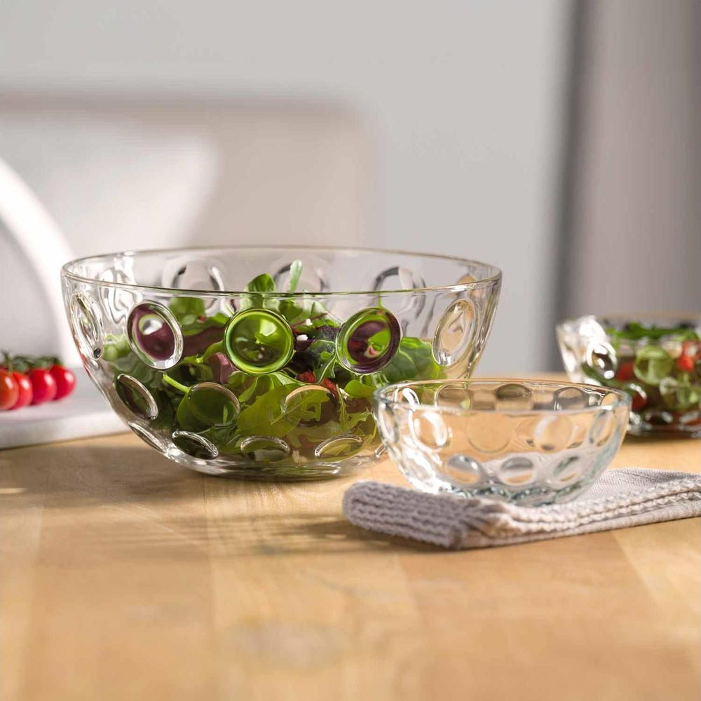Drei Glasschüsseln mit Blasenmuster. Eine große gefüllt mit Salat, eine kleine leer.