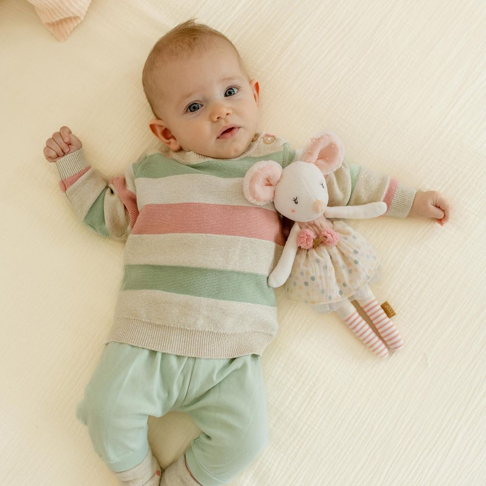 Bambino con maglione a righe e peluche topo su sfondo chiaro.