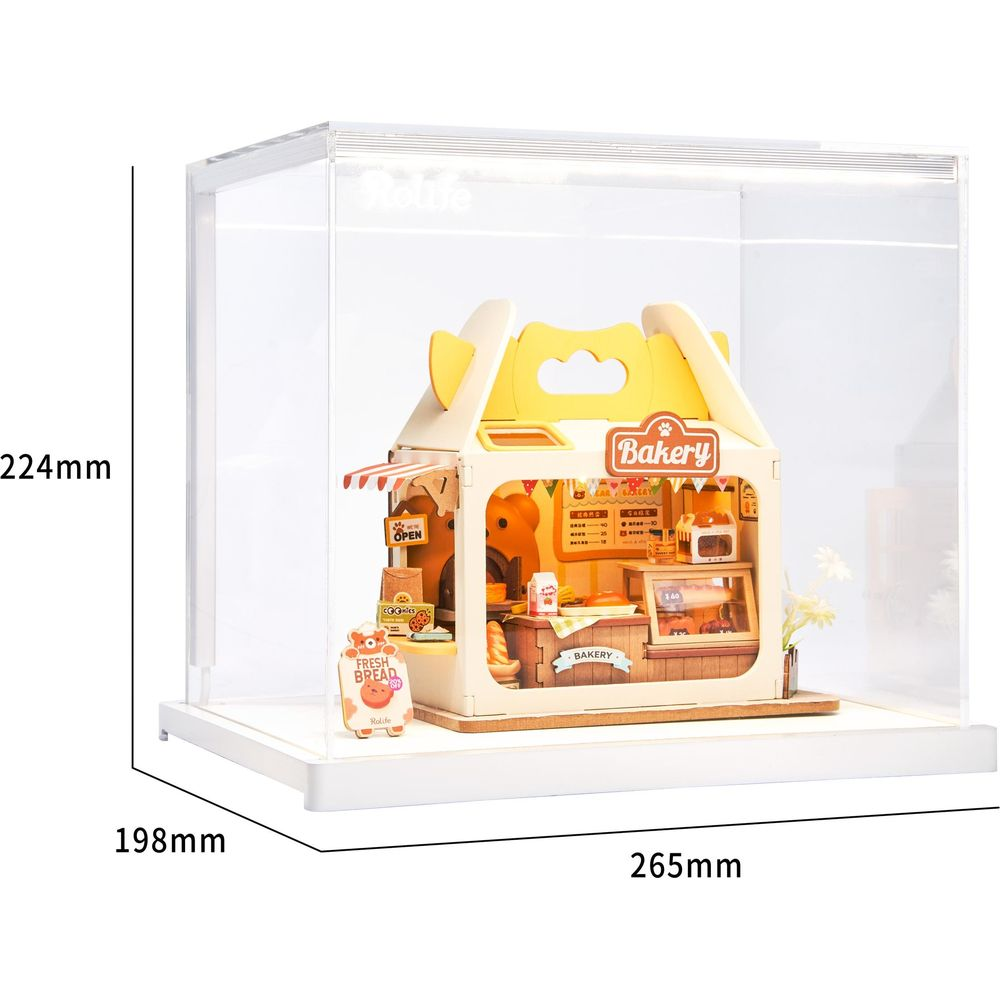 Un modello di panetteria in miniatura con tetto giallo, insegne e vetrine.