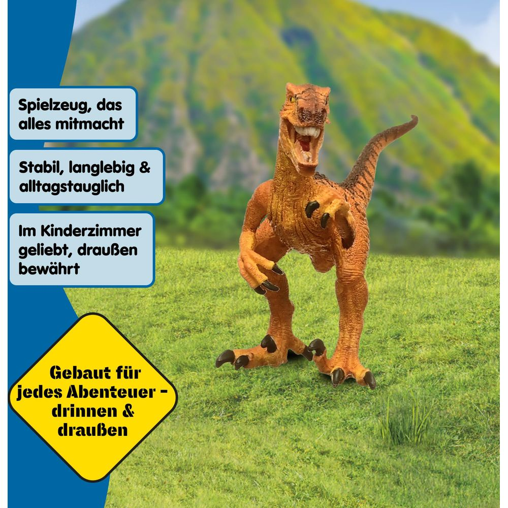 Een oranje dinosaurus speelgoed op groen gras voor bergen.