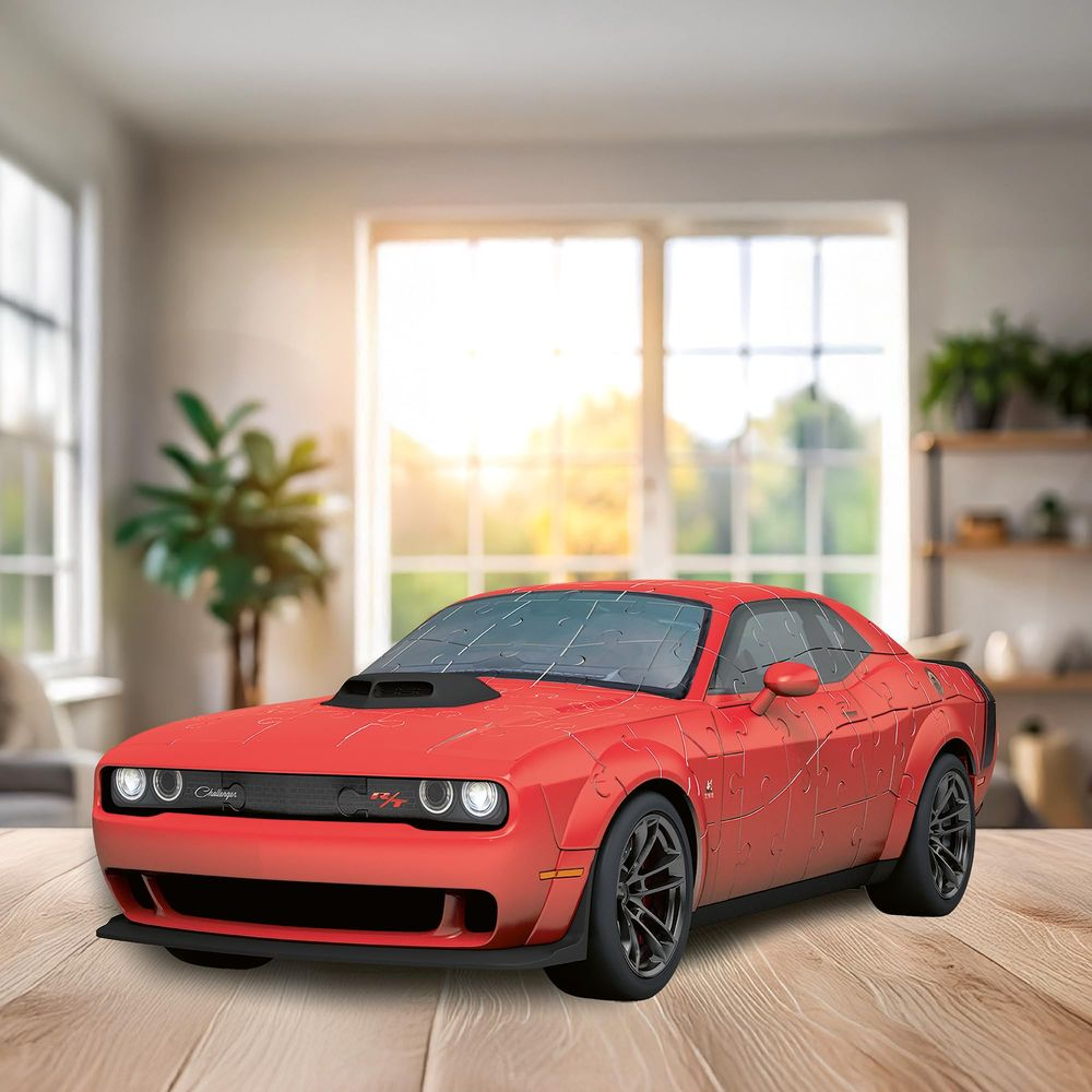 Ein roter Dodge Challenger als 3D-Puzzle auf einem Holztisch.