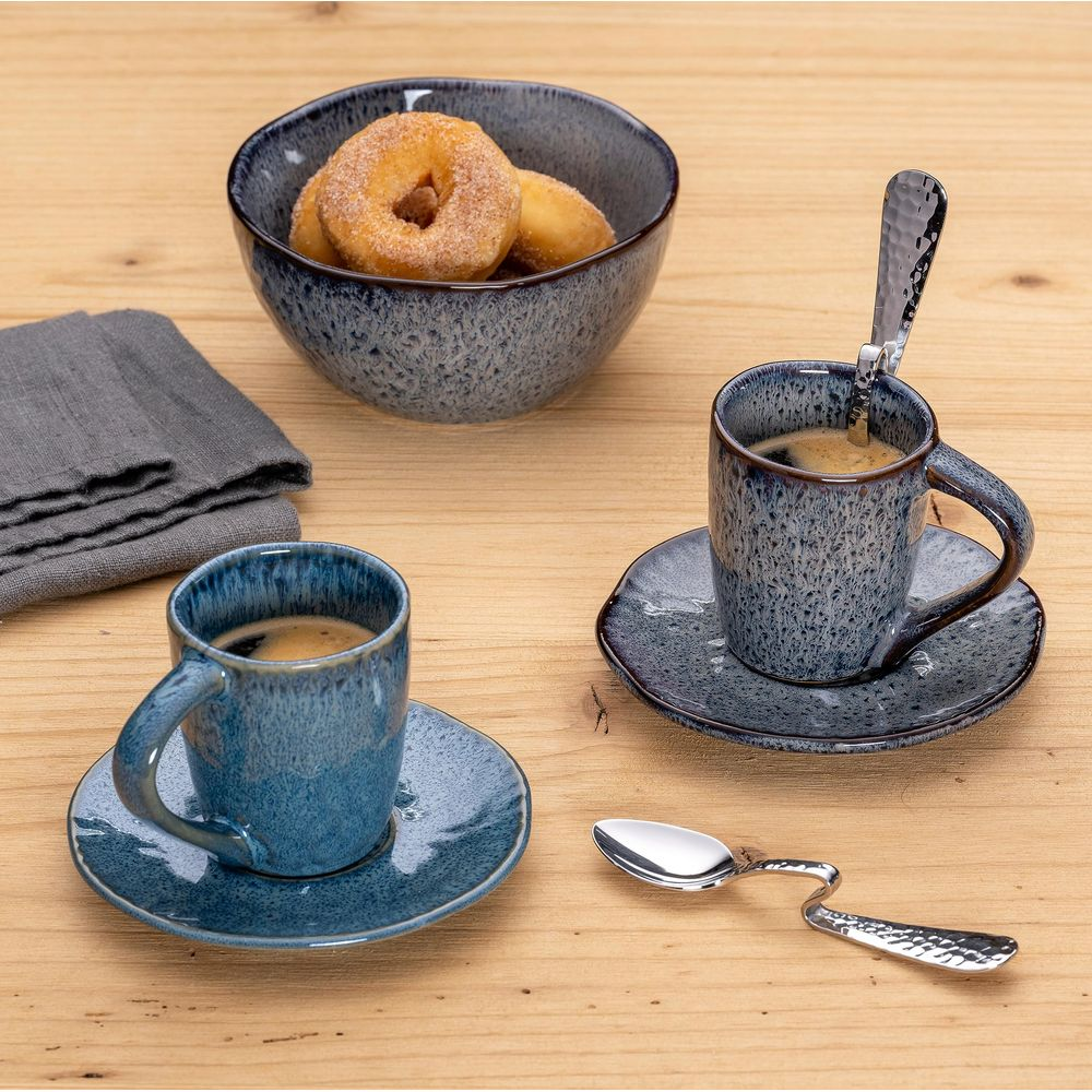 Due tazze da caffè blu con espresso e una ciotola di ciambelle allo zucchero.