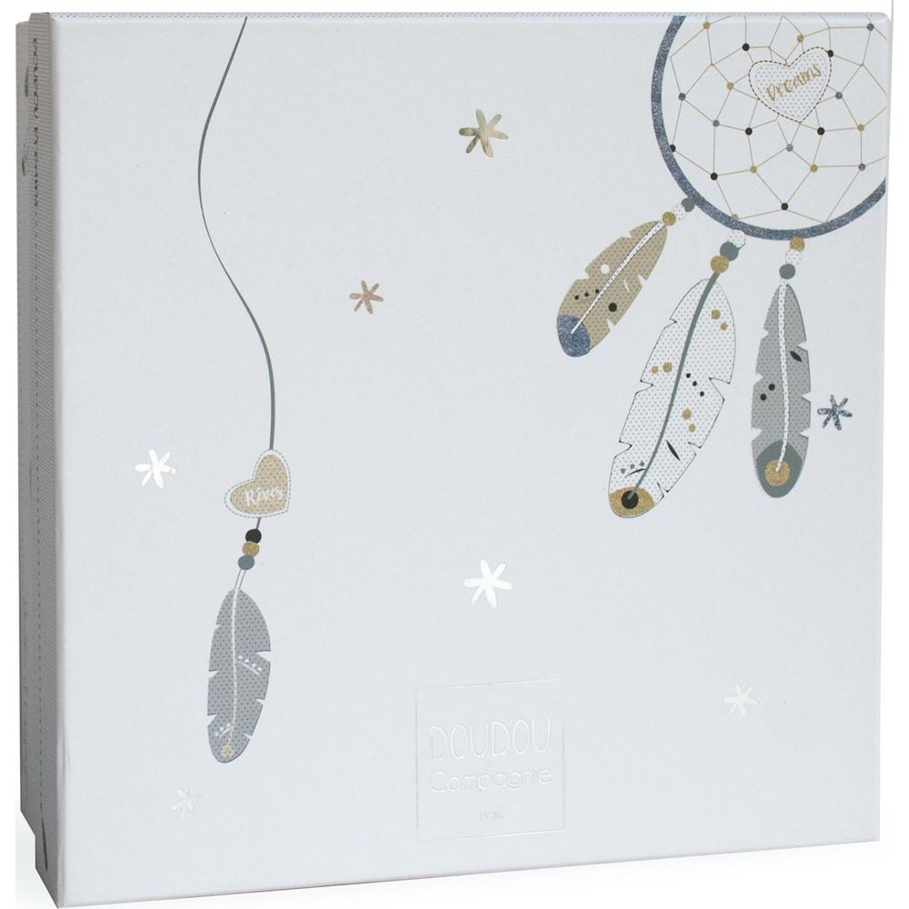 Łapacz snów z piórami i gwiazdami na białym pudełku.
