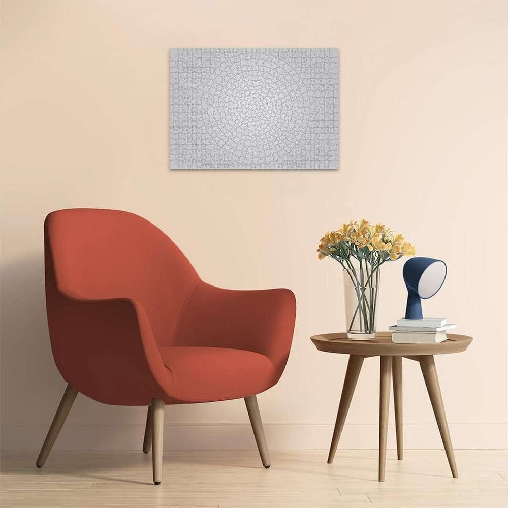 Een rode fauteuil naast een ronde tafel met bloemen en lamp.