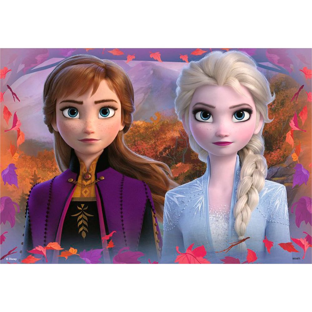 Anna ed Elsa sono una accanto all'altra in una foresta autunnale, circondate da foglie.