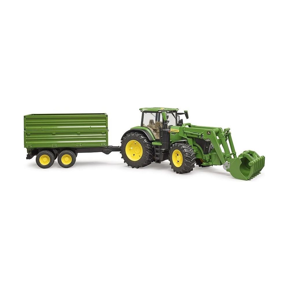 Ein grüner Spielzeugtraktor mit Frontlader und Anhänger auf weißem Hintergrund.
