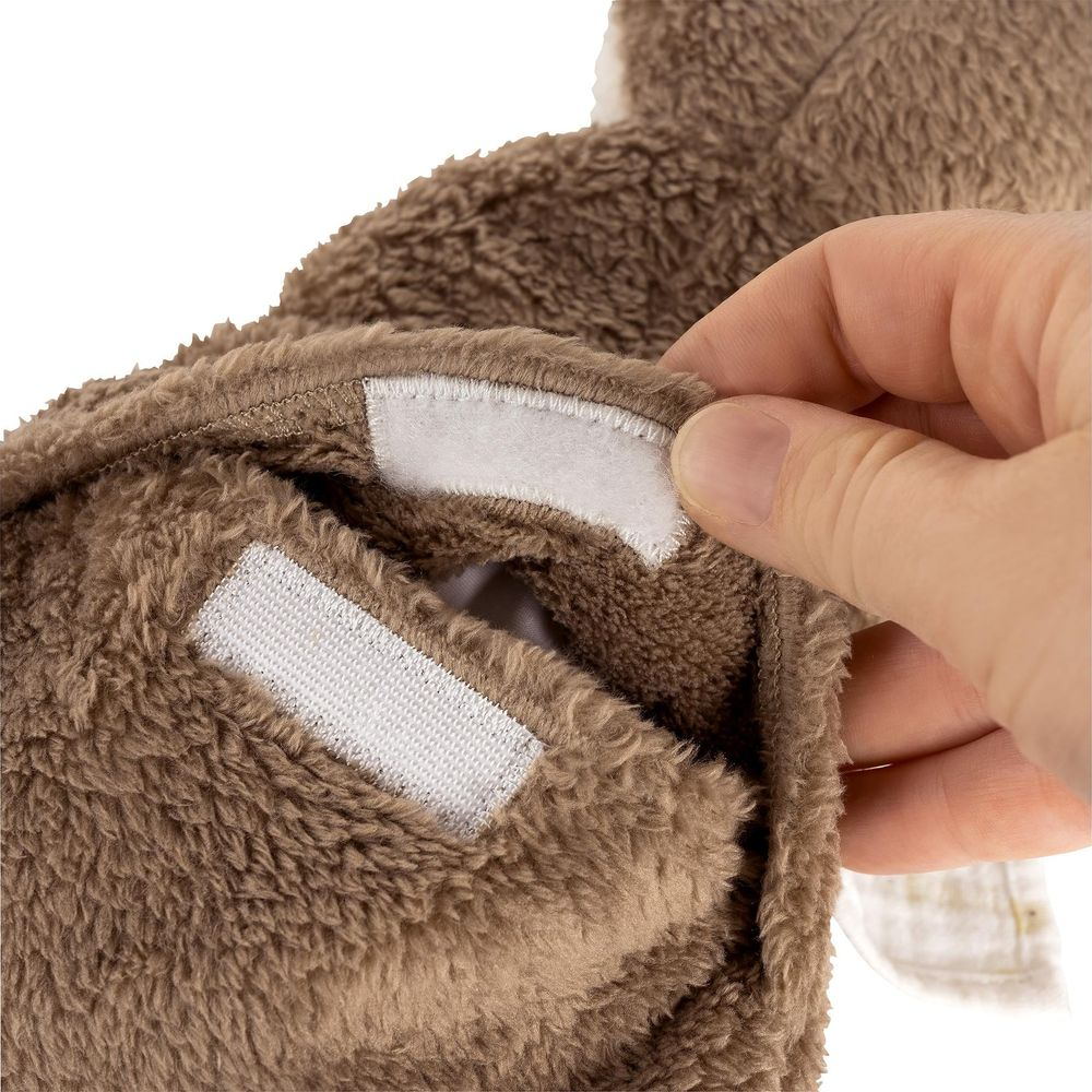 Braunes Plüschtier wird von einer Hand mit Klettverschluss geschlossen.