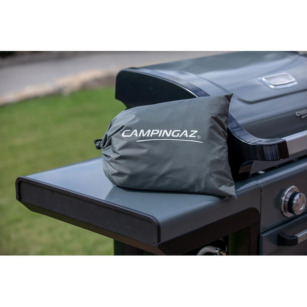 Sac Campingaz gris sur table d'appoint de grill avec fond d'herbe.