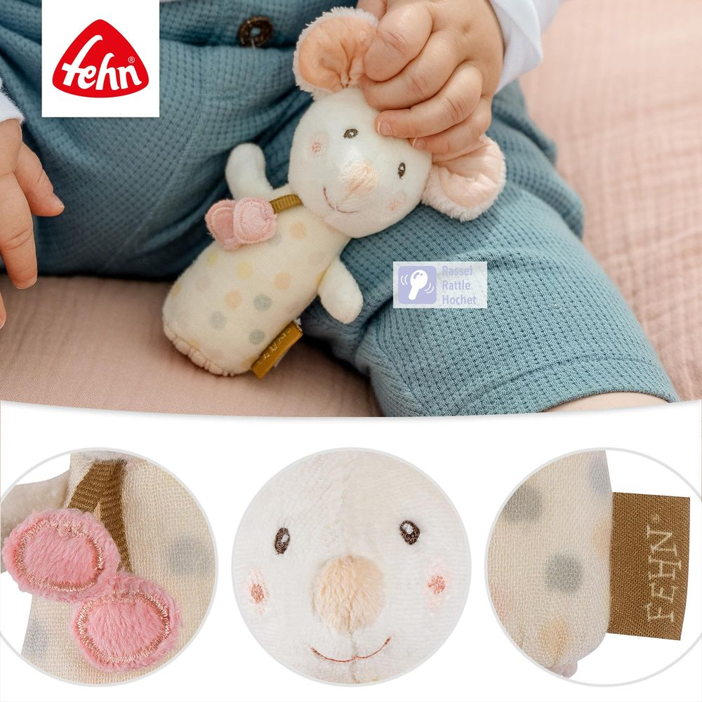 Un bébé tient une souris en peluche à pois avec des cœurs roses. Des gros plans montrent les détails.