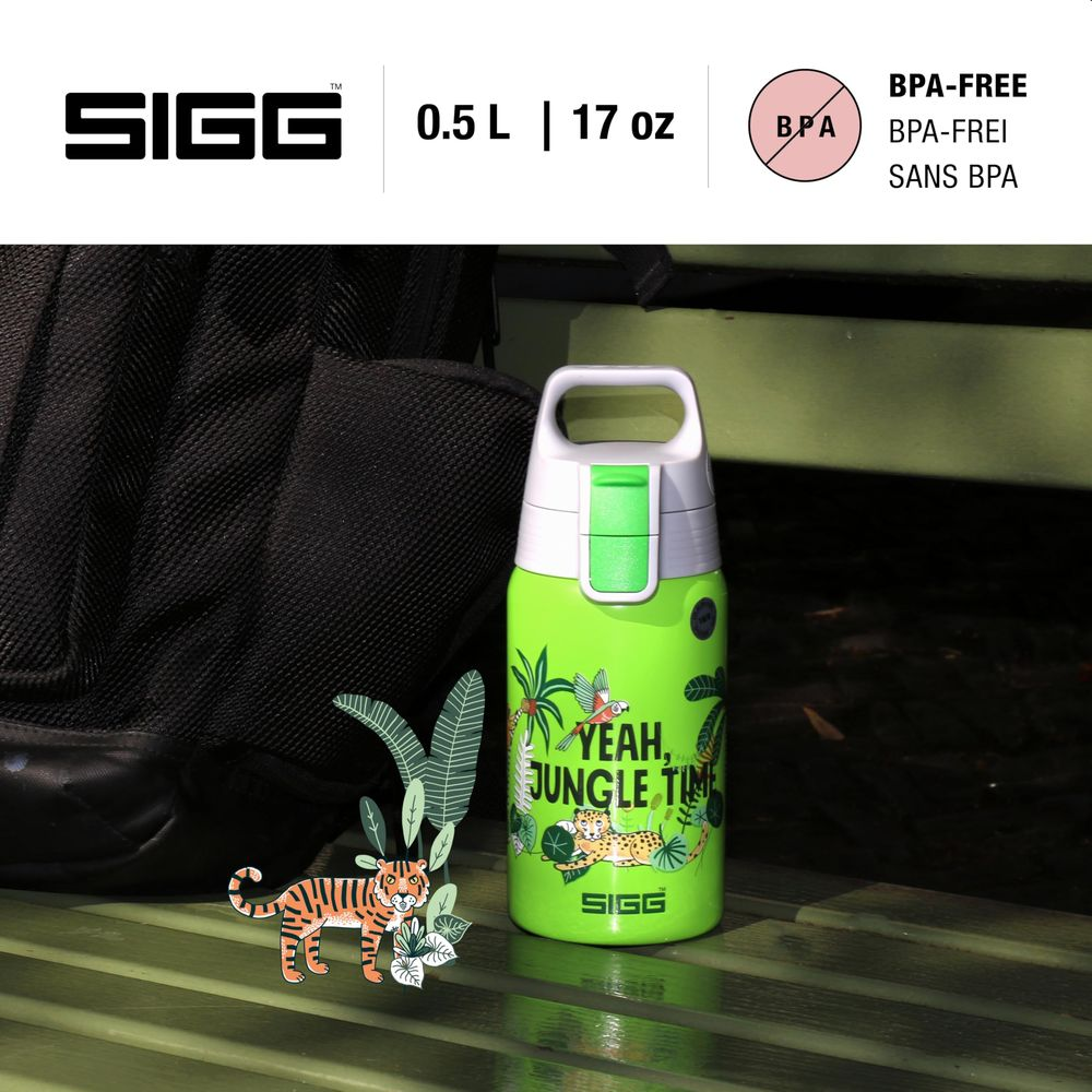 Eine grüne SIGG-Trinkflasche mit Dschungelmotiv neben einem Rucksack.