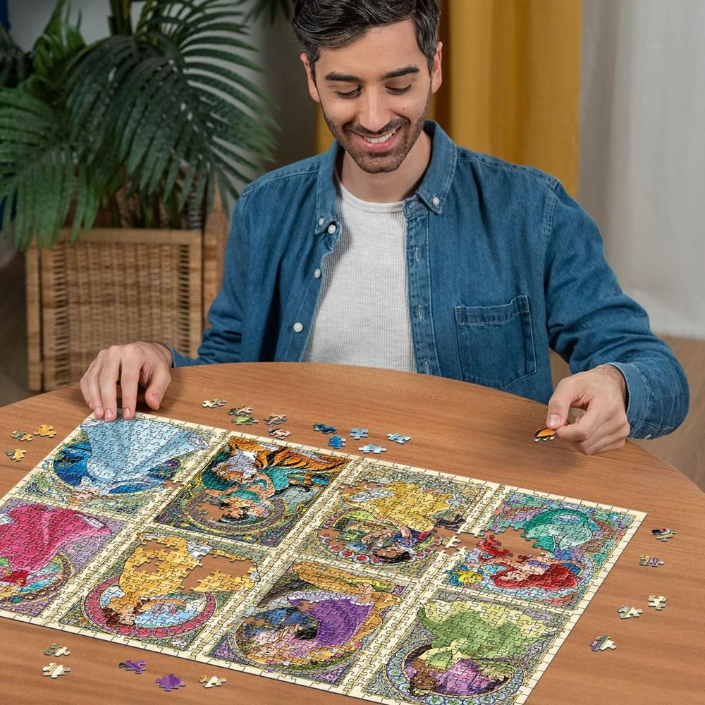 Mężczyzna układa puzzle z motywami księżniczek Disneya.
