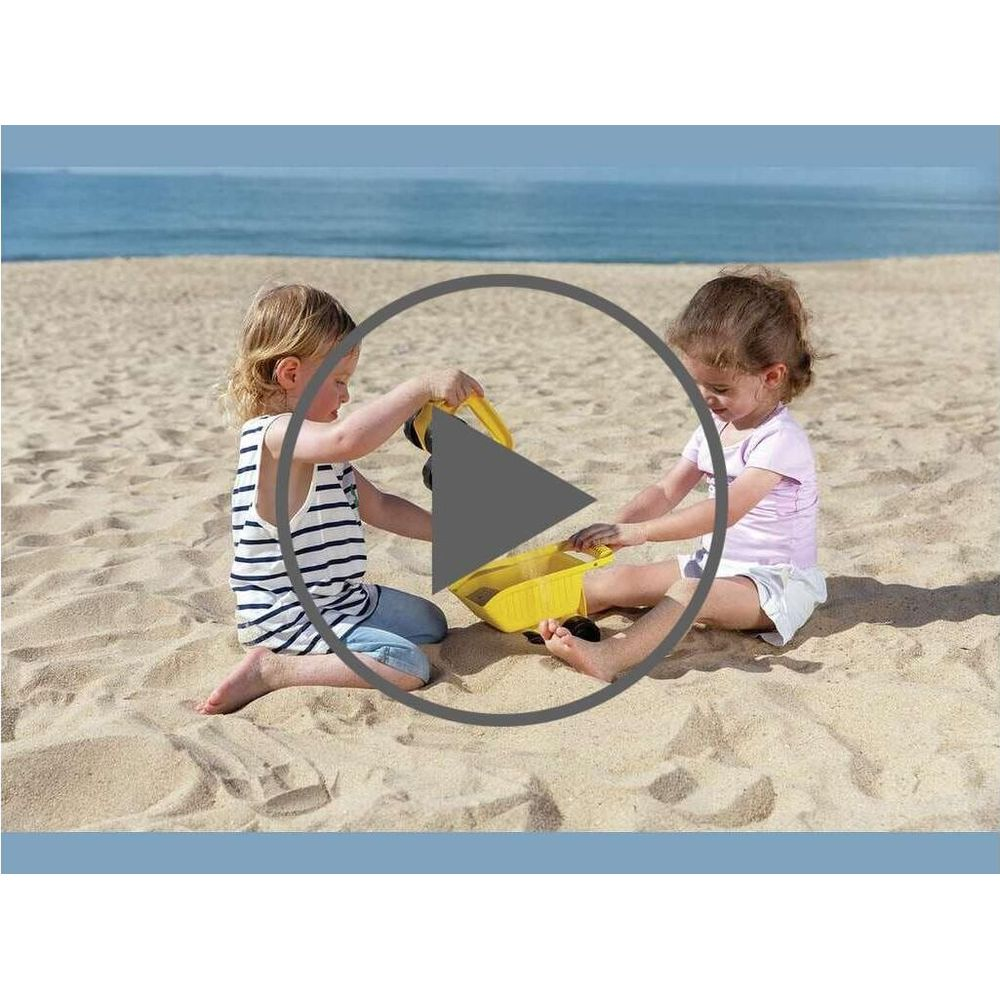 Due bambini giocano con un camioncino giallo sulla spiaggia.