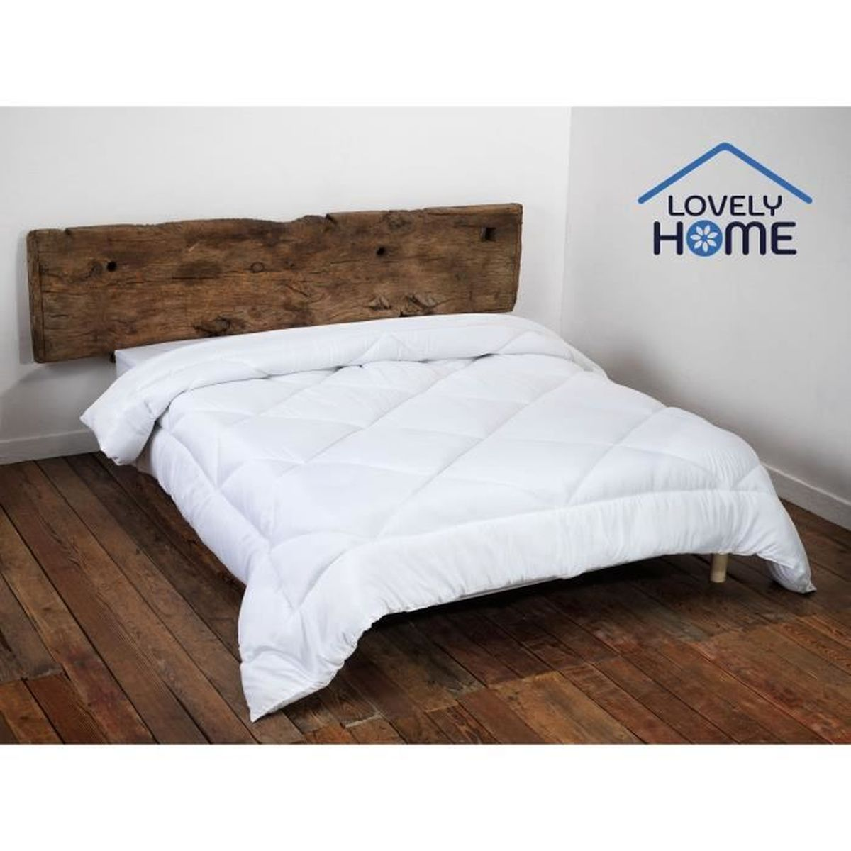 Ein weiß gestepptes Bett mit Holz-Kopfteil und Holzboden.