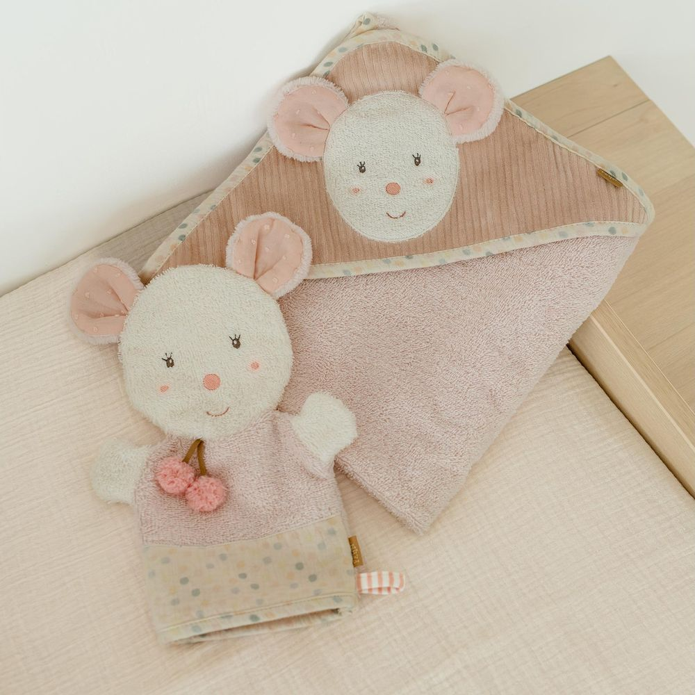 Un guanto da bagno rosa per neonati a tema topo con dettagli a ciliegia e un asciugamano con cappuccio abbinato su una superficie rosa chiaro.