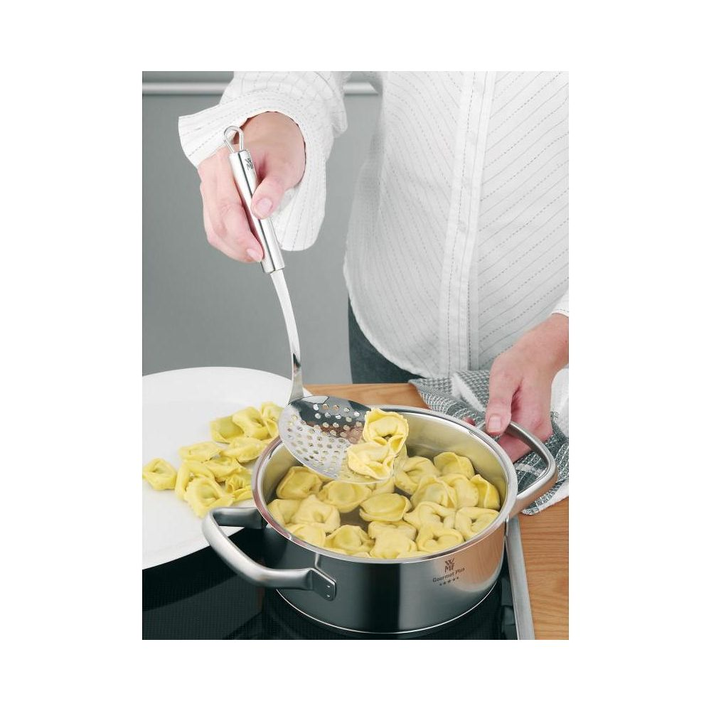 Bir el, kaynar su dolu tencereden kevgir yardımıyla tortellini çıkarıyor.