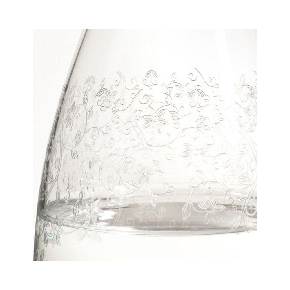 Klares Glas mit floralem Muster am oberen Rand. Unten ist etwas Flüssigkeit.