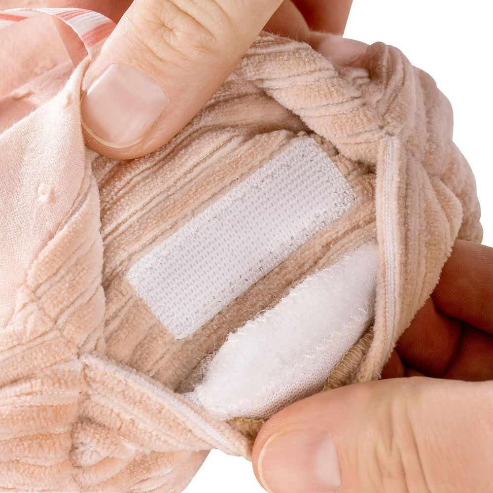 Mani che tengono un tessuto marrone chiaro a coste con velcro.