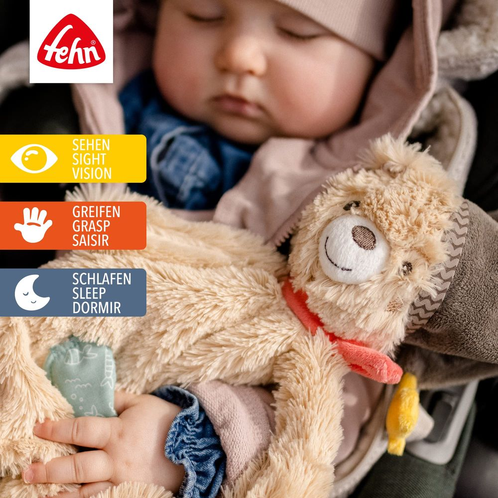 Ein Baby schläft mit einem Kuscheltier. Fehn-Logo oben links.