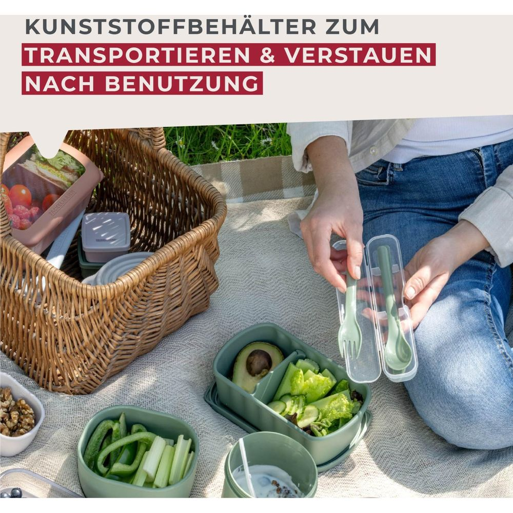 Person packt Besteck in eine transparente Hülle, neben Picknickbehältern und einem Korb.