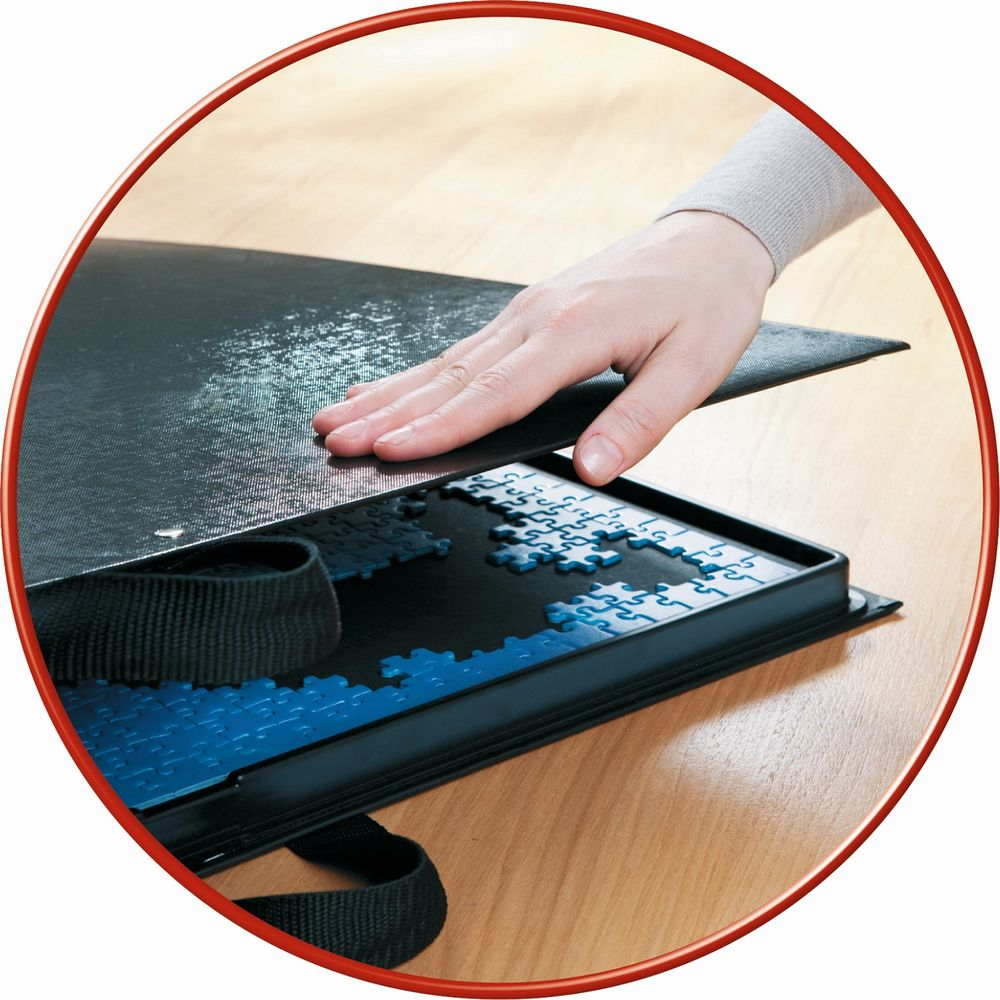 Eine Hand legt eine schwarze Abdeckung auf ein Puzzle mit blauen Teilen.