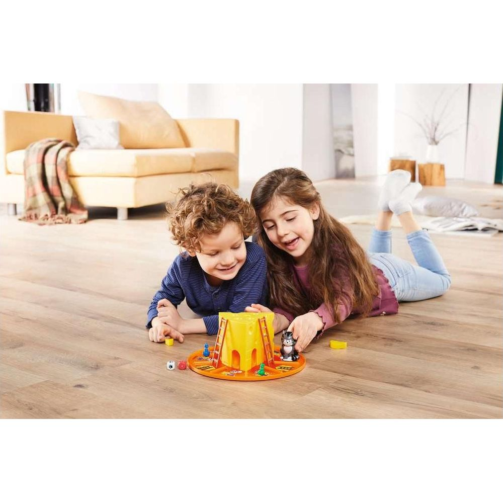 Dos niños tumbados juegan a un juego de mesa con una pirámide amarilla.