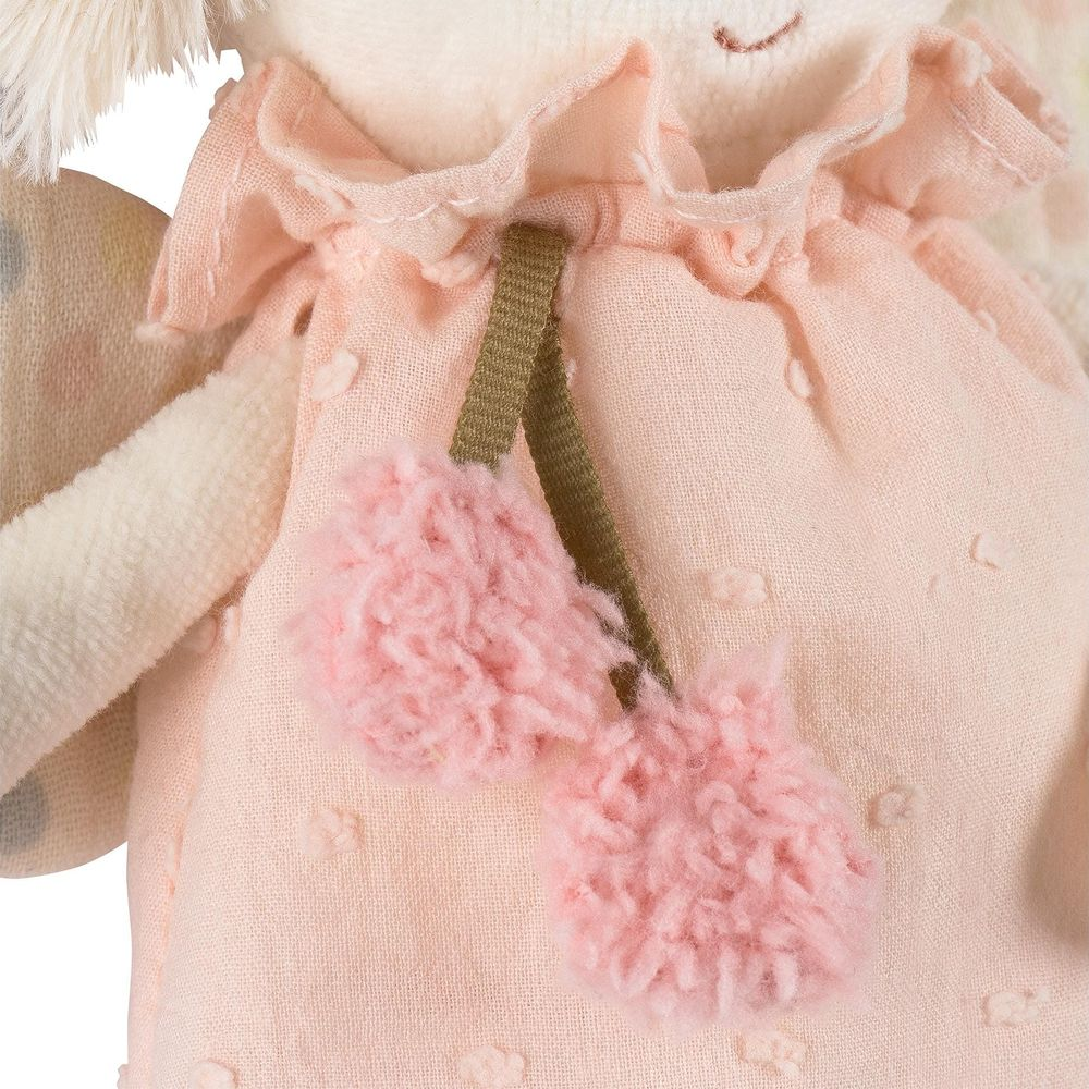 Un morbido peluche rosa con colletto arricciato e pompon.