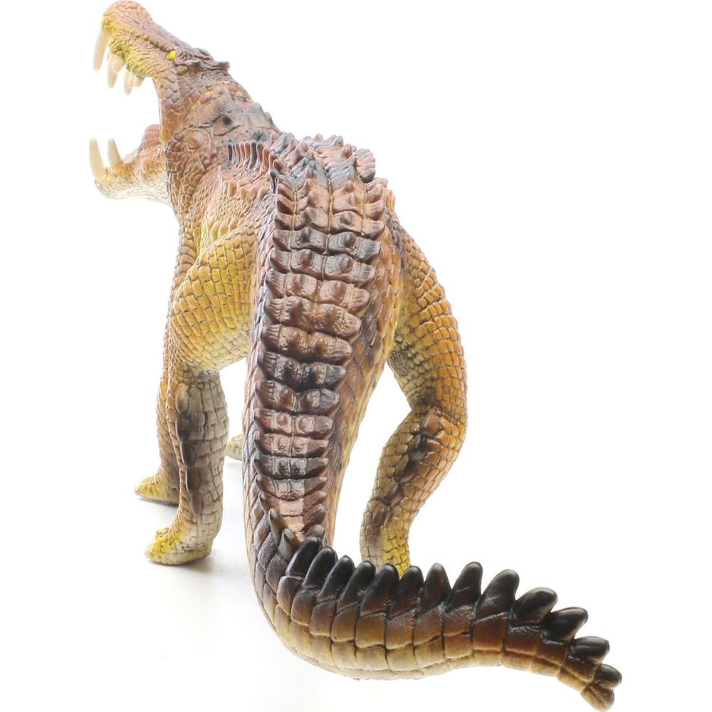 Brązowa zabawka-krokodyl z otwartą paszczą i ostrymi zębami na białym tle.