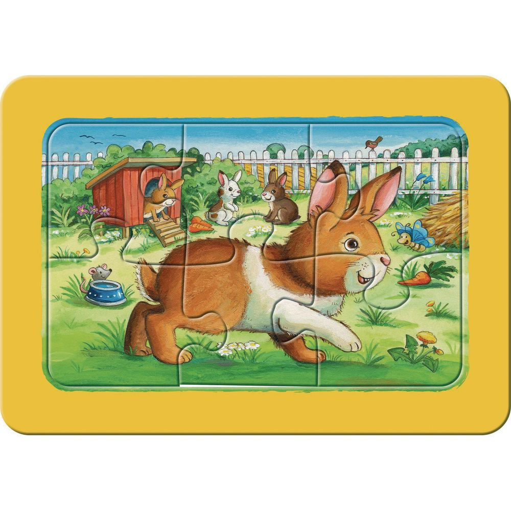 Ein braun-weißer Hase läuft auf einer grünen Wiese mit anderen Hasen und einem Vogelhaus.