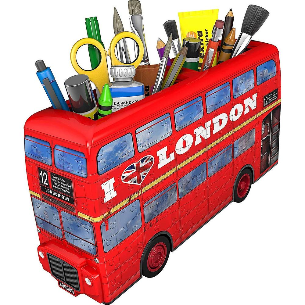 Czerwony londyński autobus piętrowy na przybory piśmiennicze z długopisami, nożyczkami i pędzlami.