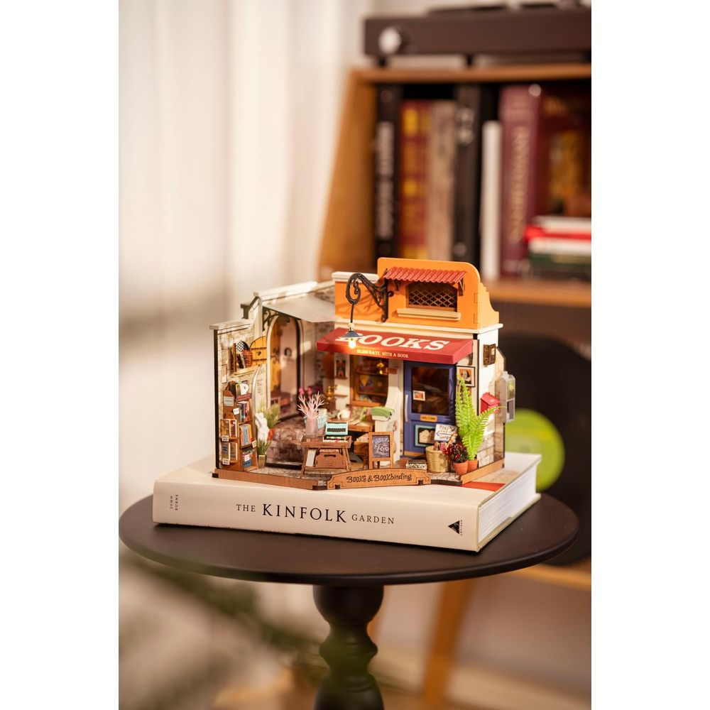 Miniaturowa księgarnia z napisem 'Books', na książce.