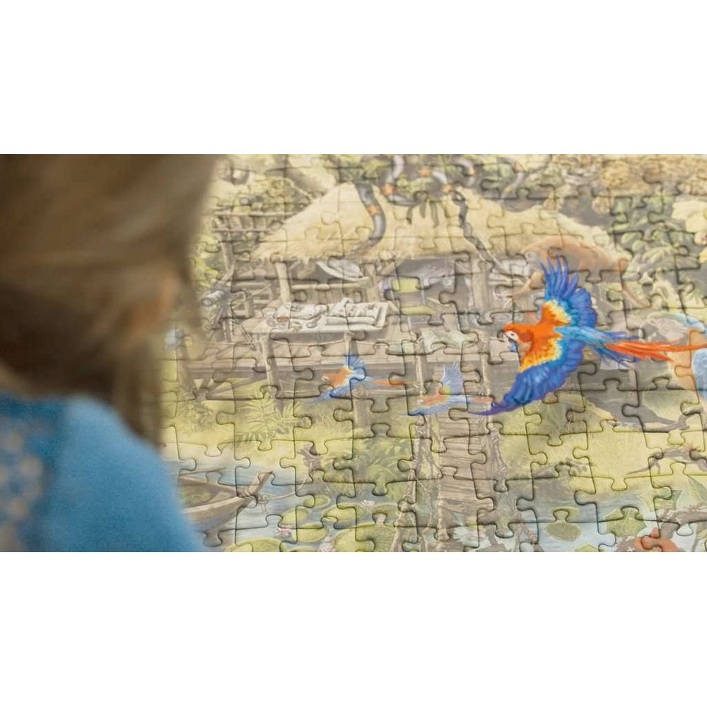 Una bambina guarda un puzzle con una scena di giungla e pappagalli in volo.