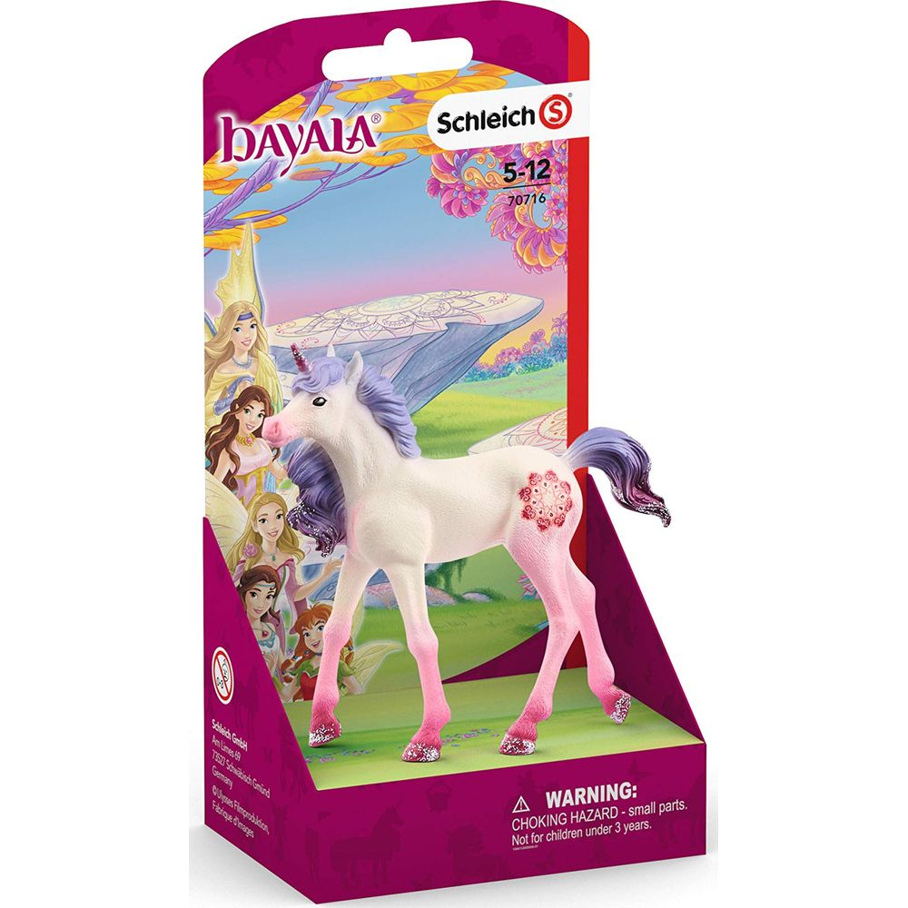 Biały jednorożec-zabawka z różowymi nogami i fioletową grzywą na tle bajkowej sceny.