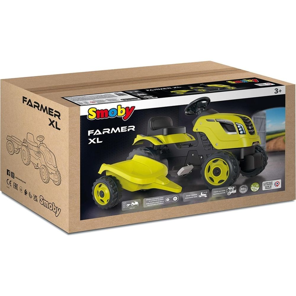 Ein gelber Smoby Farmer XL Spielzeugtraktor mit Anhänger auf einer Verpackung.
