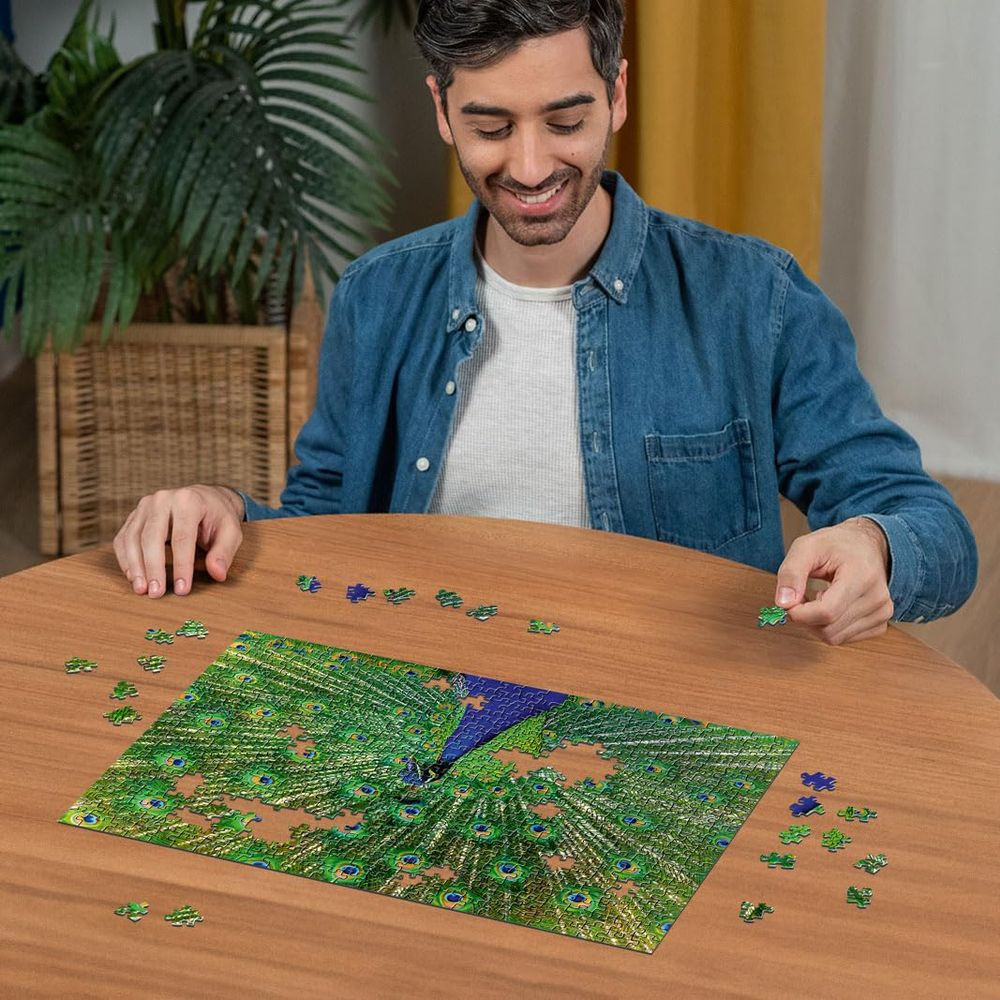 Mann löst ein Puzzle mit einem Pfau auf dem Tisch.