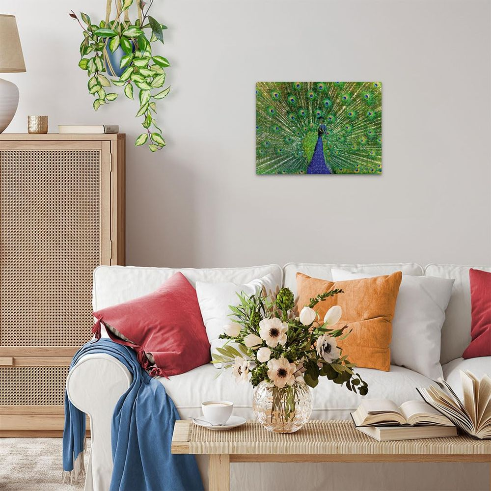 Ein Pfau mit aufgefächerten Federn hängt als Bild an der Wand über einem Sofa.